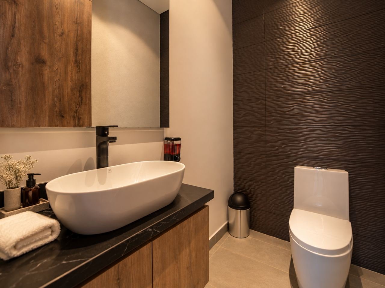 Vessel basin on a dark countertop with a textured wall