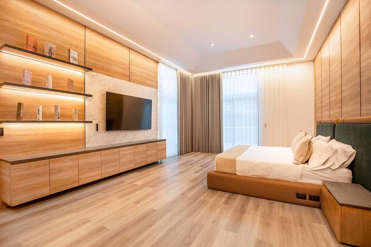 Habitación con muro en madera, nichos iluminados y mueble flotante