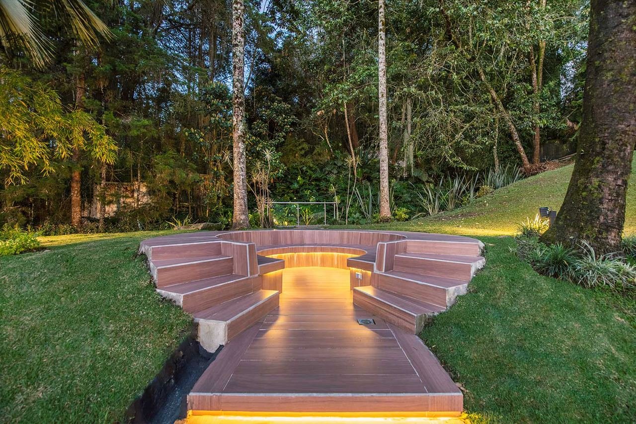 Zona de fogata en el jardín con iluminación integrada