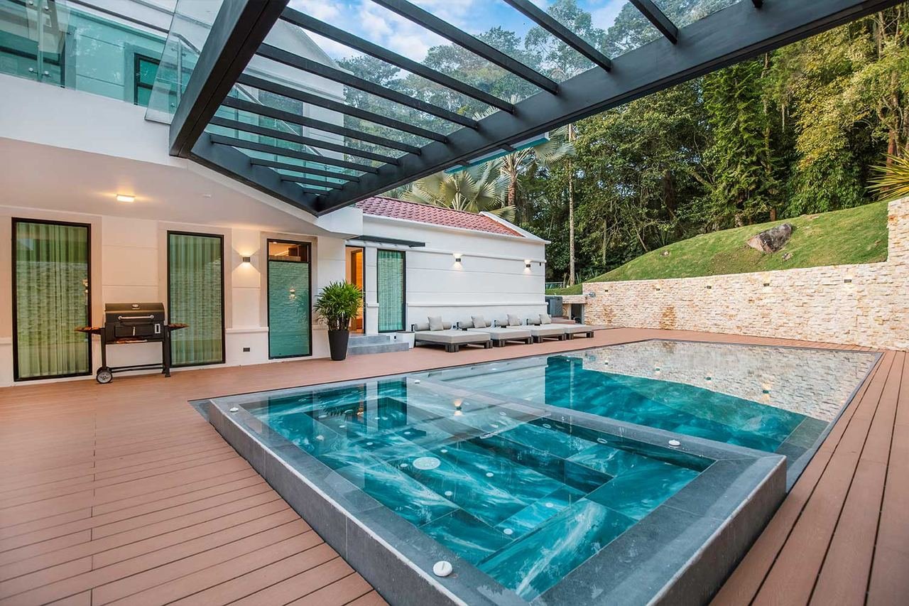 Jacuzzi bajo cubierta de vidrio con deck en madera