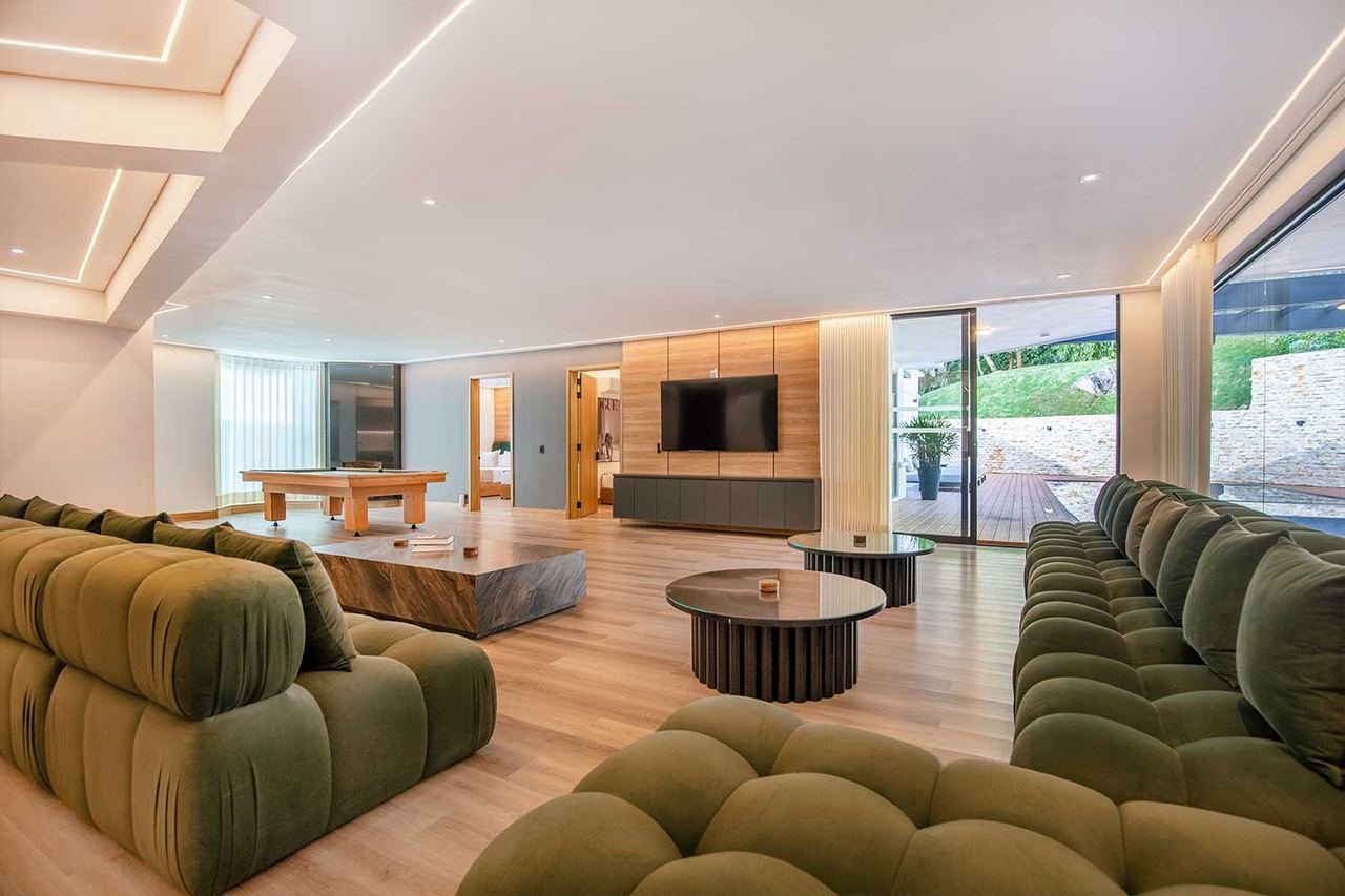 Zona social amplia con sofás modulares y piso en madera
